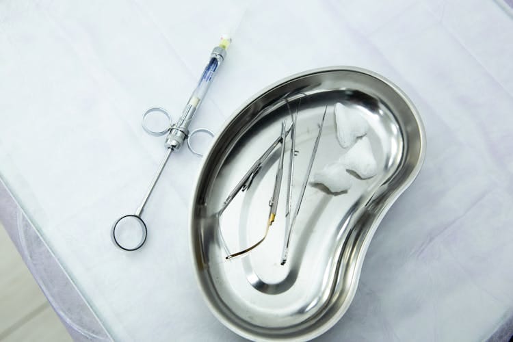 Een set steriele medische instrumenten en een spuit in een niervormig schaaltje voor tandheelkunde of chirurgie. Reisgezondheidsgids Turkije.