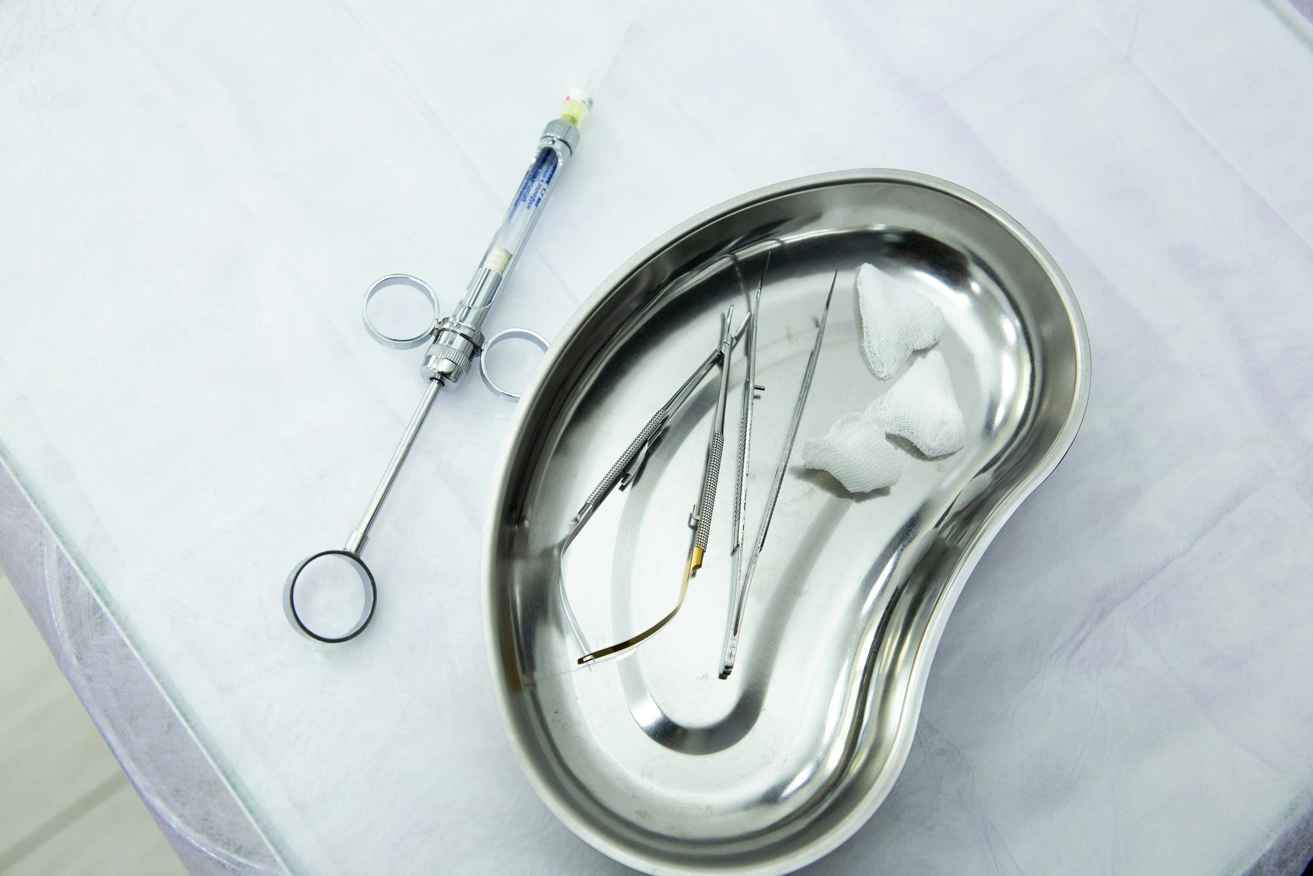 A set of sterile medical tools and syringe displayed in a kidney tray for dental or surgery. Turkey Travel Health Guide.
