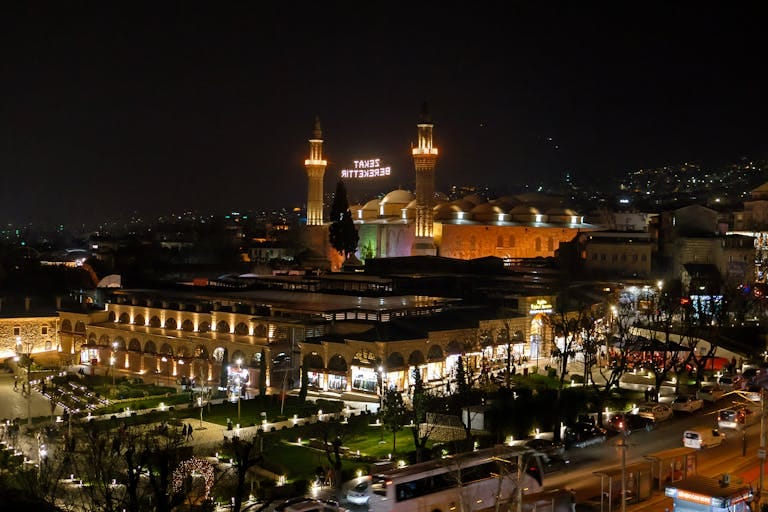 A stunning nighttime view of the Bursa Grand Mosque and surrounding area, beautifully illuminated.