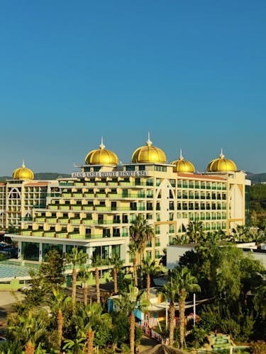 Luchtfoto van een de-luxe resort met gouden koepels in Alanya, Turkije, omringd door weelderig groen. Waar te verblijven in Turkije.