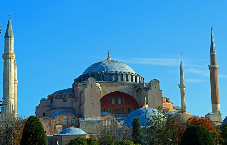 The majestic Hagia Sophia Mosque in Istanbul stands under a bright blue sky, highlighting its historical significance.