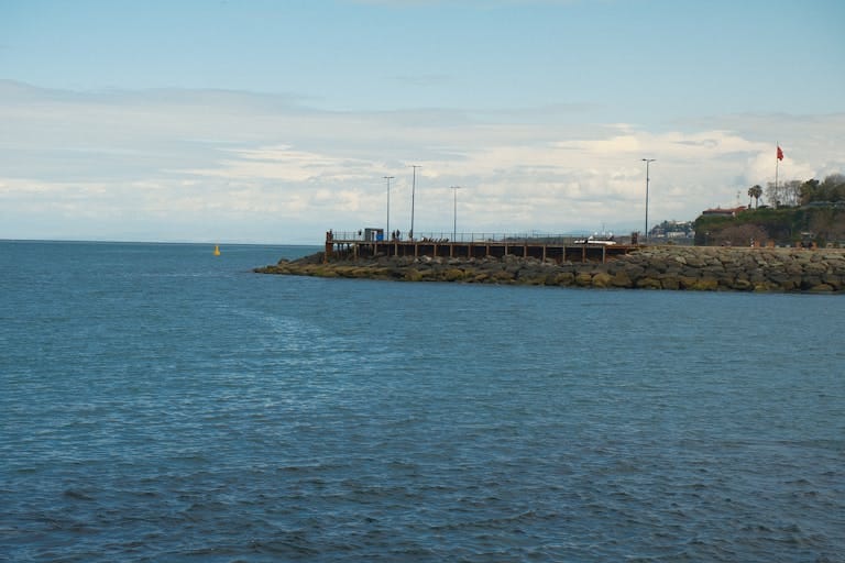 Tranquil coastal view of the Black Sea with a rocky pier in Trabzon, Türkiye.